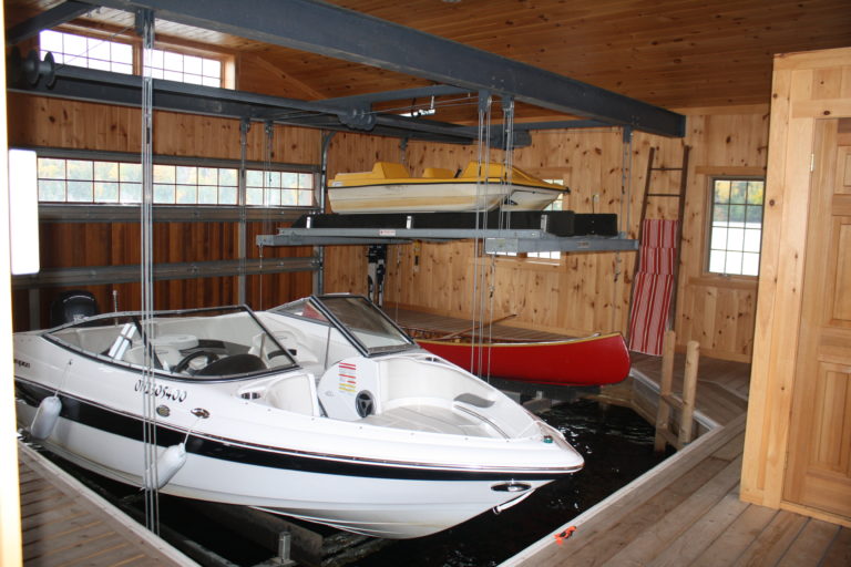 A boat inside a boat house using a platform-like bed and overhead boat lift