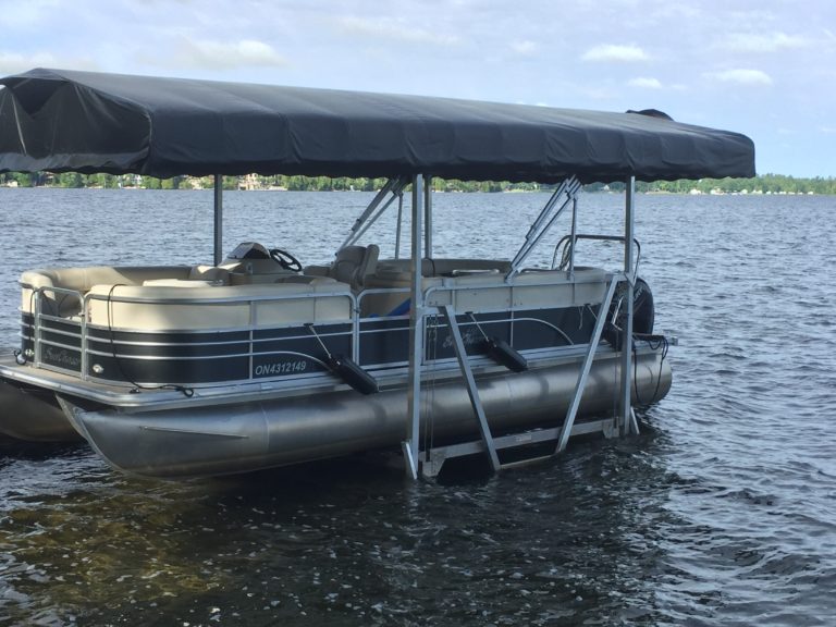 Vertical pontoon boat lift with black canopy