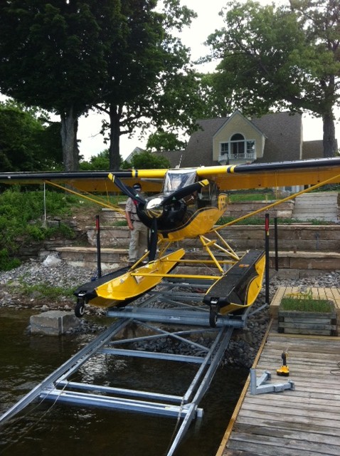 A float plane docked at the shoreline of a cottage property. 