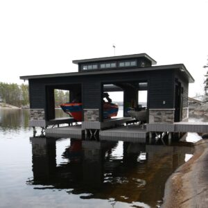 A boat house with hidden boat list raised up with boats on them.