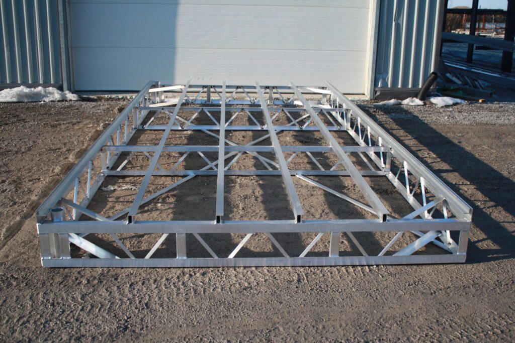 A decking metal frame laid out on a gravel surface