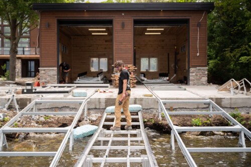 Builders working on boathouse with metal railways