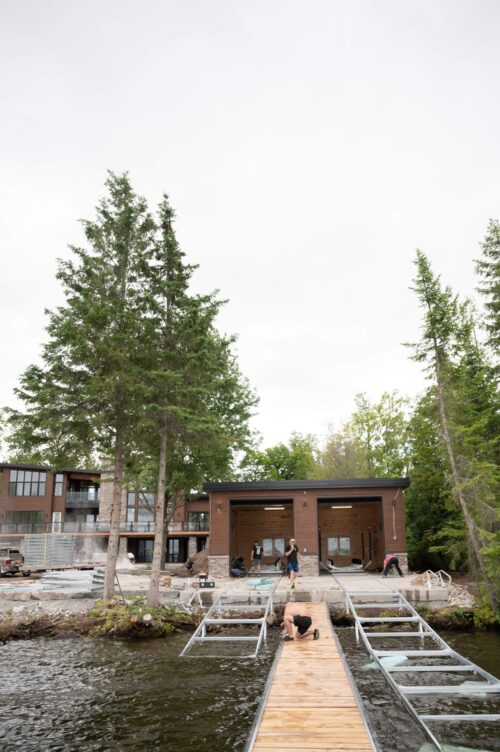 Small boathouse with two metal railways surrounded by trees