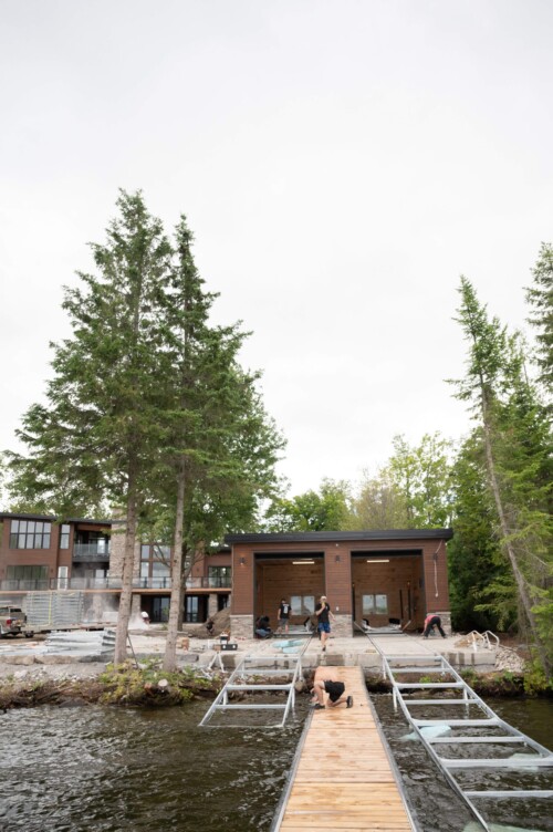 Small boathouse with two metal railways surrounded by trees