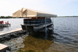 Pontoon docked on a boatlift with canopy
