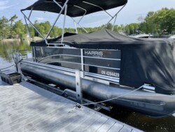Pontoon docked on a boatlift next to a composite dock over water