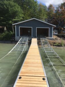 A long WaveX dock connected to a boat house with boat ramps on either side.