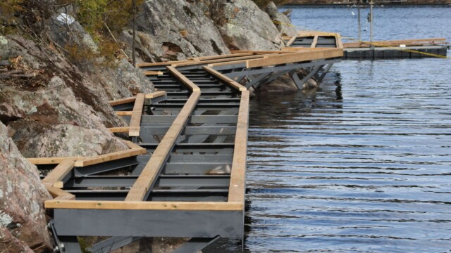 Deck framing and rock formations next to a lake