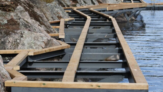 Deck framing and rock formations next to a lake