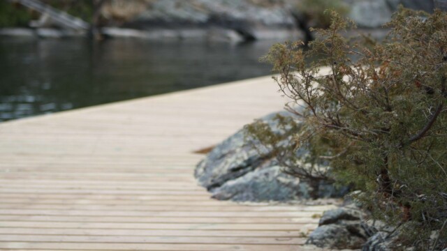 Wooden deck within rock formations next to a lake