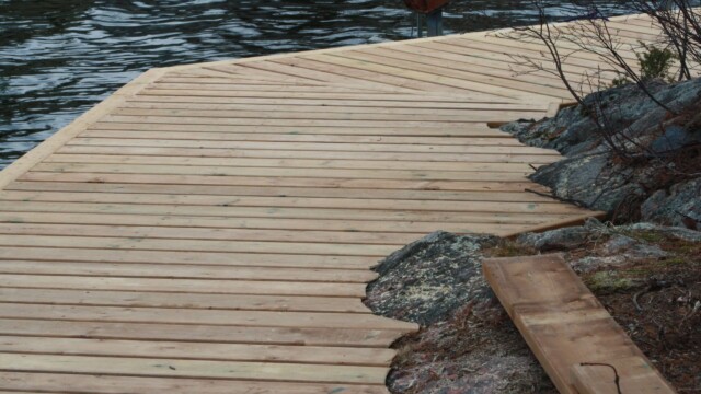 Wooden deck within rock formations next to a lake