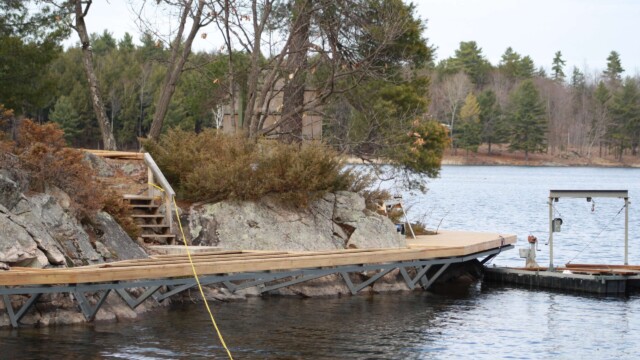 Deck framing and rock formations next to a lake