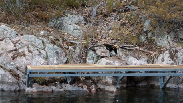 Deck framing and rock formations next to a lake