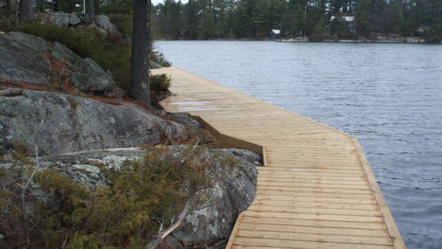 Wooden deck within rock formations next to a lake