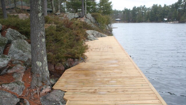 Wooden deck within rock formations next to a lake