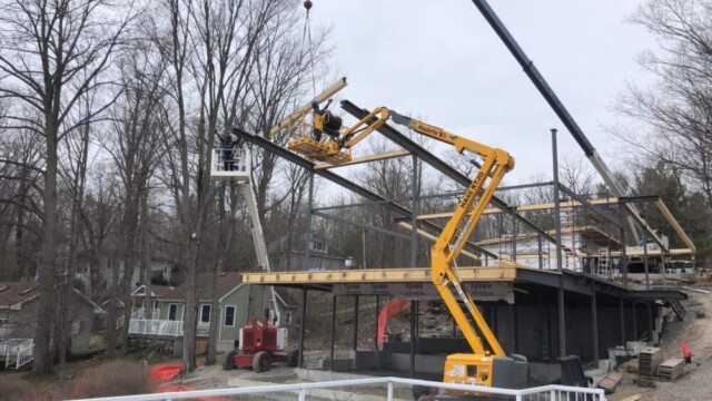 Crane lifting beams onto a house structure