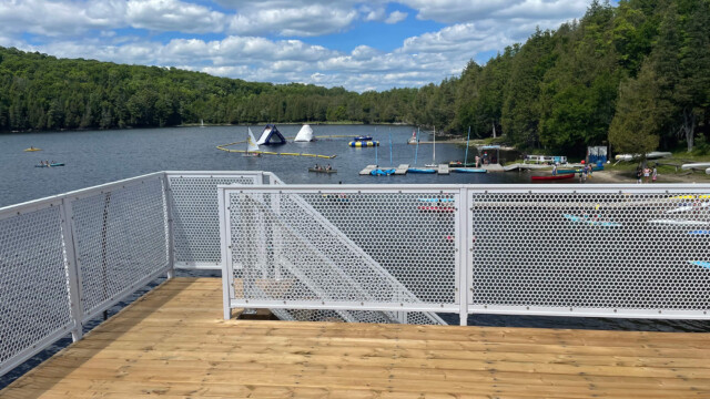 Metal railings onlooking a beach with kayaks