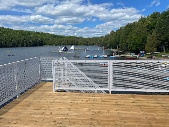 Metal railings onlooking a beach with kayaks